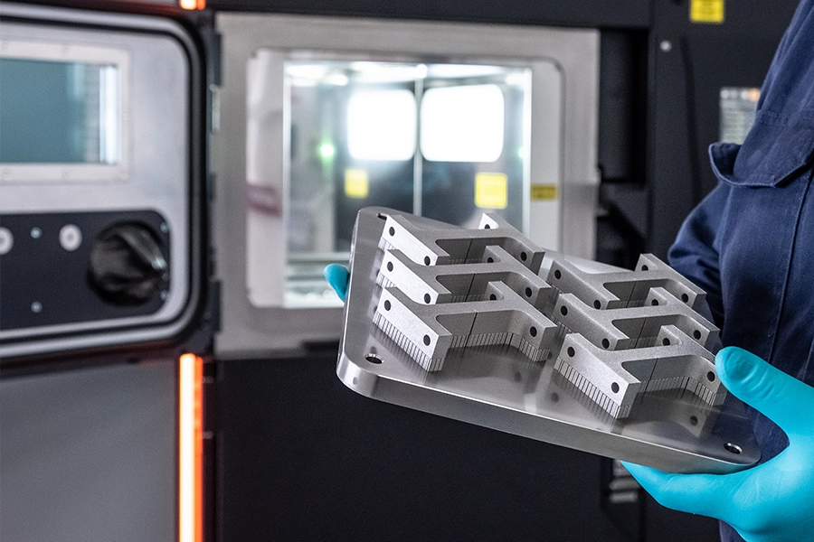 3D print platform displaying multiple additive manufactured metal bars.